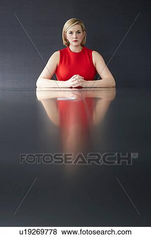 Woman sitting at desk hands together looking at camera View Large Photo Image Stock Photo - Woman sitting at desk hands together looking at camera. Fotosearch