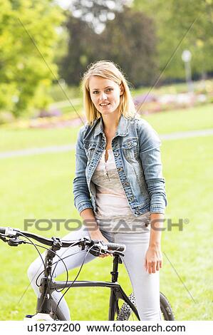 Stock Image - Woman sitting on a bicycle. Fotosearch