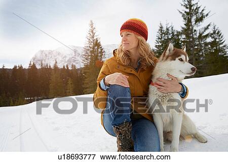 Woman sitting with husky in snow covered landscape, Elmau, Bavaria, Germany View Large Photo Image Stock Photo - Woman sitting with husky in snow covered landscape, Elmau, Bavaria, Germany. Fotosearch