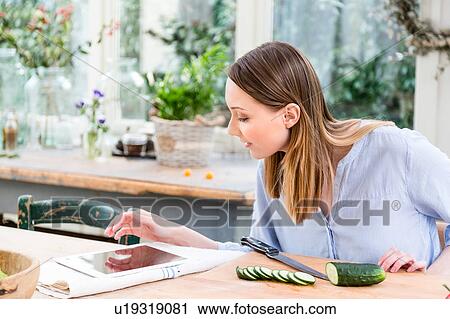Woman slicing cucumber using digital tablet View Large Photo Image Stock Image - Woman slicing cucumber using digital tablet. Fotosearch