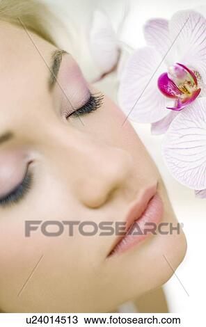 Woman smelling orchid flowers View Large Photo Image Stock Image - Woman smelling orchid flowers. Fotosearch