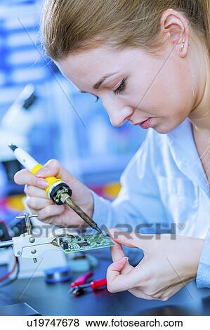 Woman soldering a printed circuit board View Large Photo Image Stock Photo - Woman soldering a printed circuit board. Fotosearch