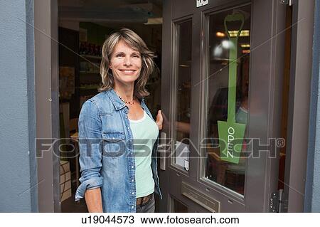Woman standing in doorway of shop View Large Photo Image Stock Image - Woman standing in doorway of shop. Fotosearch