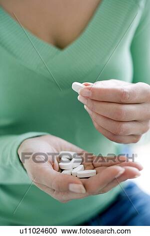 Stock Image - Woman taking medication. Fotosearch