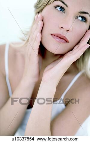 Woman touching her face View Large Photo Image Picture - Woman touching her face. Fotosearch
