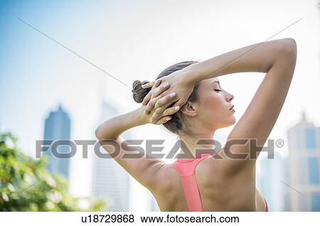 Woman training, eyes closed with hands behind head in park, Dubai, United Arab Emirates View Large Photo Image Stock Photo - Woman training, eyes closed with hands behind head in park, Dubai, United Arab Emirates. Fotosearch