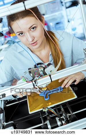 Stock Image - Woman using 3d printer. Fotosearch