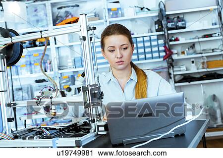 Stock Image - Woman using 3d printer. Fotosearch