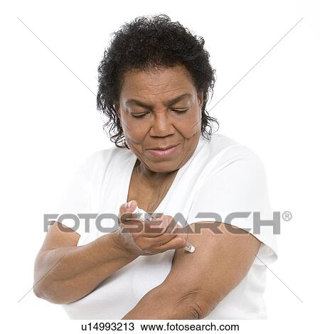 Stock Image - Woman using an insulin pen. Fotosearch