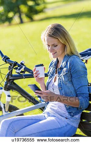 Stock Photography - Woman using cell phone with coffee. Fotosearch