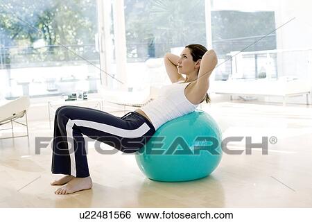Woman using exercise ball View Large Photo Image Stock Photograph - Woman using exercise ball. Fotosearch