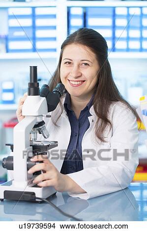Picture - Woman using microscope. Fotosearch