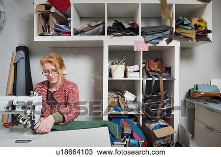 Woman using sewing machine in workshop View Large Photo Image Stock Image - Woman using sewing machine in workshop. Fotosearch