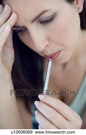 Stock Photo - Woman using thermometer. Fotosearch