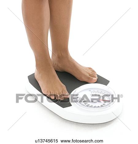 Stock Photography - Woman weighing herself. Fotosearch