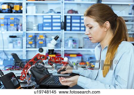 Woman working on a robotic arm View Large Photo Image Stock Photography - Woman working on a robotic arm. Fotosearch