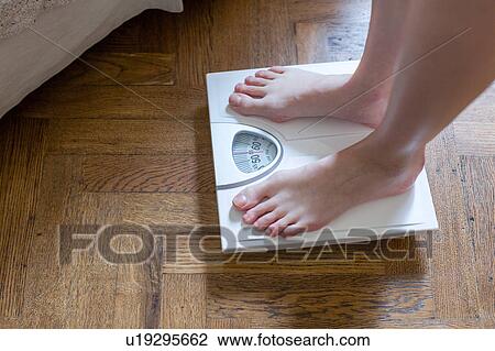 Womans feet standing on bathroom scales View Large Photo Image Stock Image - Womans feet standing on bathroom scales. Fotosearch