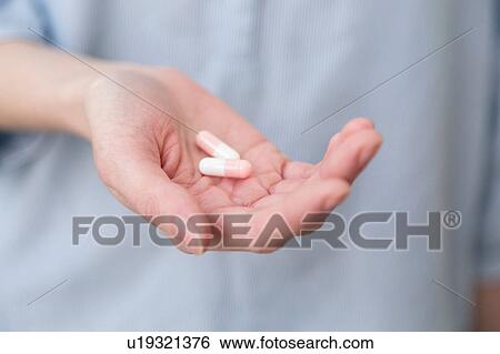 Womans hand holding capsules View Large Photo Image Stock Photograph - Womans hand holding capsules. Fotosearch