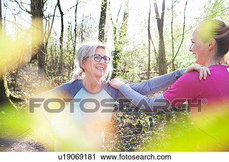 Women in forest, hand on each others shoulders stretching View Large Photo Image Stock Image - Women in forest, hand on each others shoulders stretching. Fotosearch