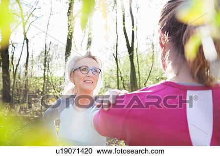 Women in forest, hand on each others shoulders stretching View Large Photo Image Stock Image - Women in forest, hand on each others shoulders stretching. Fotosearch