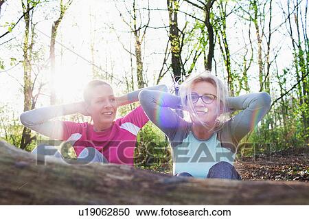 Women in forest hands behind head doing sit up against fallen tree View Large Photo Image Stock Image - Women in forest hands behind head doing sit up against fallen tree. Fotosearch