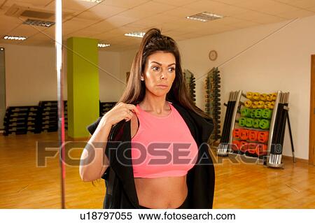 Stock Photography - Women in gym wearing crop top looking away. Fotosearch