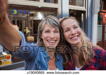 Women taking selfie looking at camera smiling View Large Photo Image Stock Photography - Women taking selfie looking at camera smiling. Fotosearch