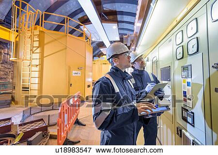 Workers checking data in generating hall in hydroelectric power station View Large Photo Image Stock Photo - Workers checking data in generating hall in hydroelectric power station. Fotosearch