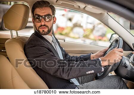 Young businessman driving car looking over his shoulder, Dubai, United Arab Emirates View Large Photo Image Stock Image - Young businessman driving car looking over his shoulder, Dubai, United Arab Emirates. Fotosearch