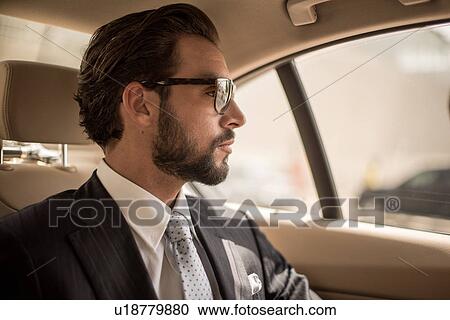 Young businessman looking out from car backseat, Dubai, United Arab Emirates View Large Photo Image Stock Image - Young businessman looking out from car backseat, Dubai, United Arab Emirates. Fotosearch