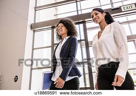 Young businesswomen arriving at office entrance View Large Photo Image Stock Image - Young businesswomen arriving at office entrance. Fotosearch