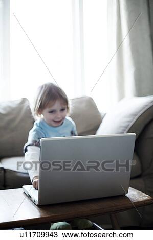 Young child playing with a laptop View Large Photo Image Stock Image - Young child playing with a laptop. Fotosearch