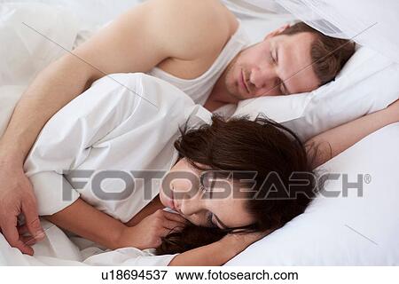 Young couple asleep in bed View Large Photo Image Stock Photo - Young couple asleep in bed. Fotosearch