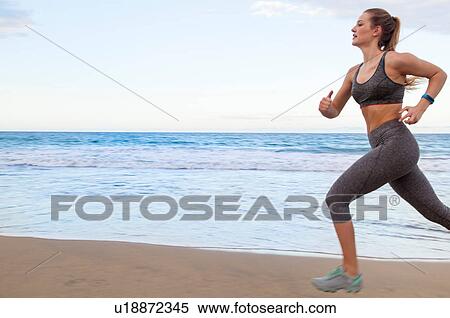 Stock Photography - Young female runner running along beach, Dominican Republic, The Caribbean. Fotosearch