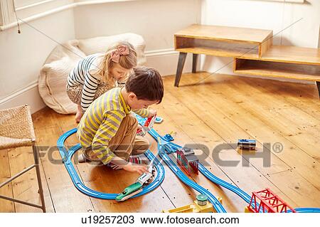 Young girl and boy playing with toy train set View Large Photo Image Stock Image - Young girl and boy playing with toy train set. Fotosearch