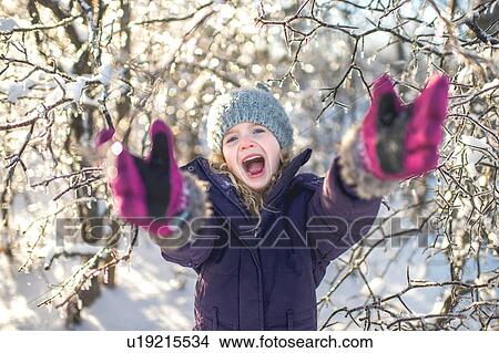 Young girl laughing, arms outstretched, in snowy landscape View Large Photo Image Picture - Young girl laughing, arms outstretched, in snowy landscape. Fotosearch