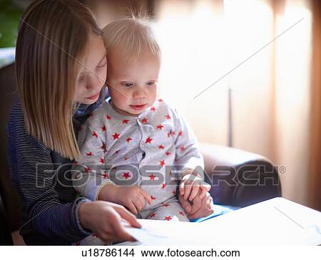 Young girl reading to baby brother View Large Photo Image Picture - Young girl reading to baby brother. Fotosearch