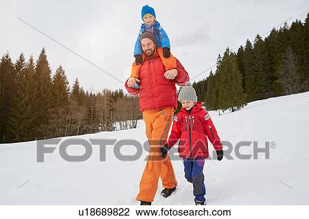 Young man shoulder carrying and walking with sons in snow covered landscape, Elmau, Bavaria, Germany View Large Photo Image Stock Image - Young man shoulder carrying and walking with sons in snow covered landscape, Elmau, Bavaria, Germany. Fotosearch