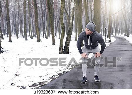 Young man taking a break from exercise, in snowy forest View Large Photo Image Stock Photo - Young man taking a break from exercise, in snowy forest. Fotosearch