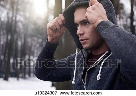 Young man wearing hooded sweatshirt, in snowy, rural landscape View Large Photo Image Stock Photo - Young man wearing hooded sweatshirt, in snowy, rural landscape. Fotosearch