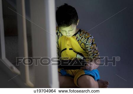Picture - Young using handheld device. Fotosearch