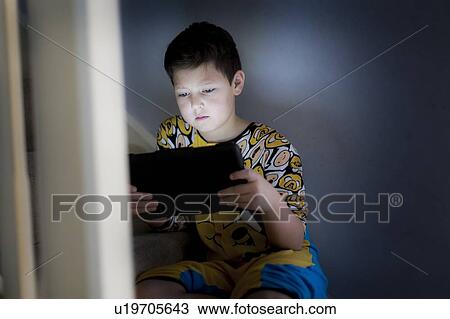Stock Image - Young using handheld device. Fotosearch
