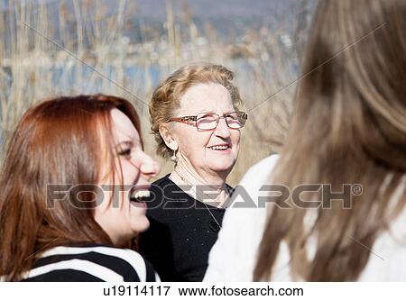 Young woman and senior woman in group smiling View Large Photo Image Stock Photo - Young woman and senior woman in group smiling. Fotosearch