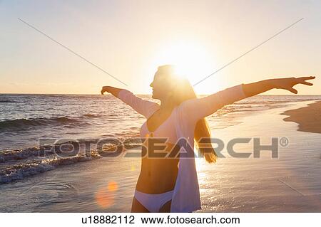 Young woman dancing with arms open on beach at sunset, Dominican Republic, The Caribbean View Large Photo Image Stock Image - Young woman dancing with arms open on beach at sunset, Dominican Republic, The Caribbean. Fotosearch