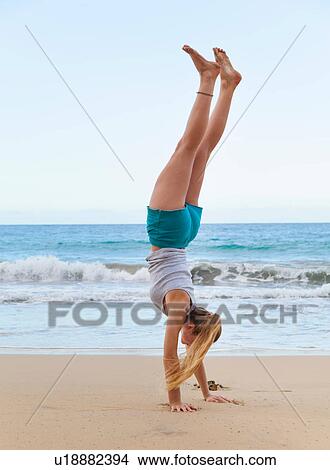 Picture - Young woman doing handstand on beach, Dominican Republic, The Caribbean. Fotosearch