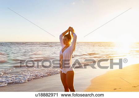 Young woman making hair ponytail on beach at sunset, Dominican Republic, The Caribbean View Large Photo Image Stock Image - Young woman making hair ponytail on beach at sunset, Dominican Republic, The Caribbean. Fotosearch
