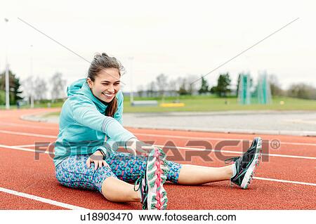 Young woman on running track, exercising, stretching View Large Photo Image Stock Image - Young woman on running track, exercising, stretching. Fotosearch