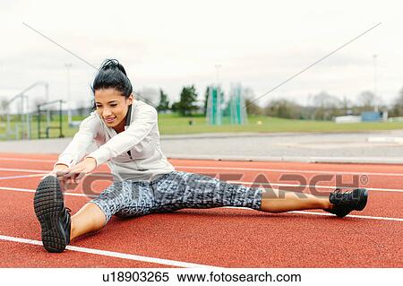 Young woman on running track, exercising, stretching View Large Photo Image Stock Photography - Young woman on running track, exercising, stretching. Fotosearch