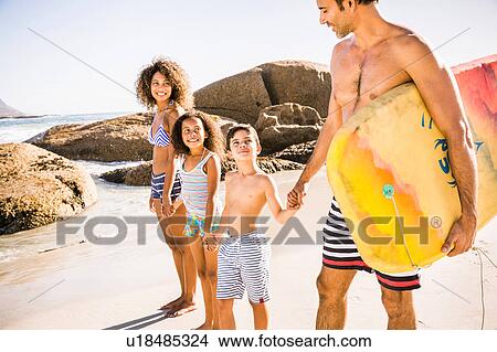 Picture - Bodyboarding couple and children on beach, Cape Town, South Africa. Fotosearch