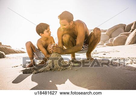 Boy and father making sandcastle on beach, Cape Town, South Africa View Large Photo Image Stock Photo - Boy and father making sandcastle on beach, Cape Town, South Africa. Fotosearch